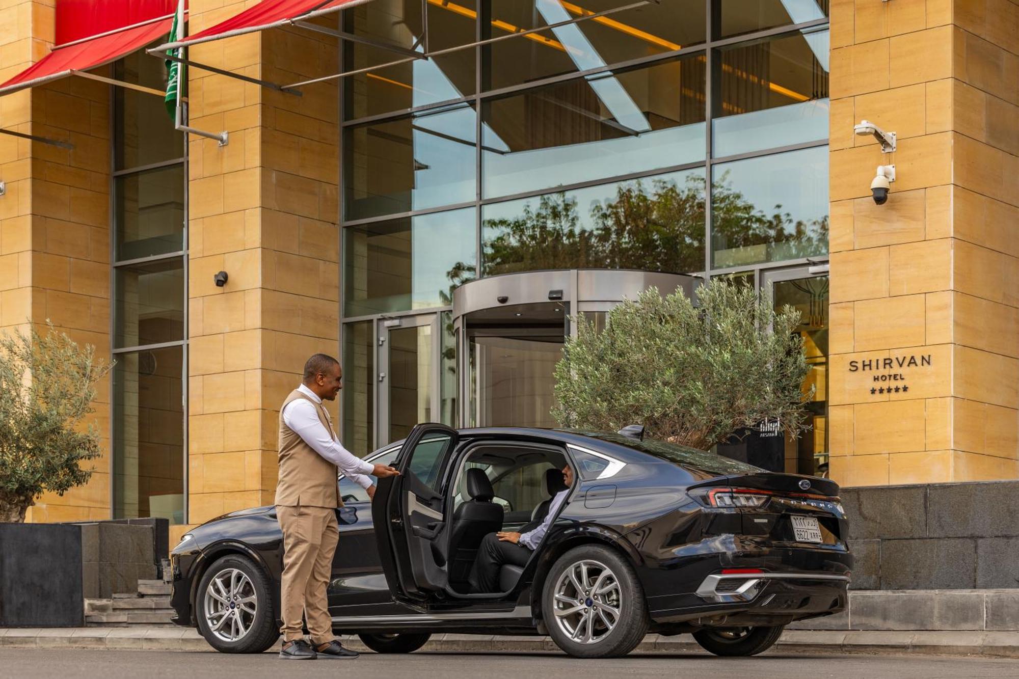 Shirvan Hotel City Yard Dschidda Exterior foto A chauffeur opening the door of a car